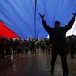 Pro-Russian demonstrators march with a huge Russian flag during a protest in front of a local government building in Simferopol, Crimea, Ukraine, Thursday, Feb. 27, 2014. Ukraine&#x27;s acting interior minister says Interior Ministry troops and police have been put on high alert after dozens of men seized local government and legislature buildings in the Crimea region. The intruders raised a Russian flag over the parliament building in the regional capital, Simferopol, but didn&#x27;t immediately voice any demands. (AP Photo/Darko Vojinovic)