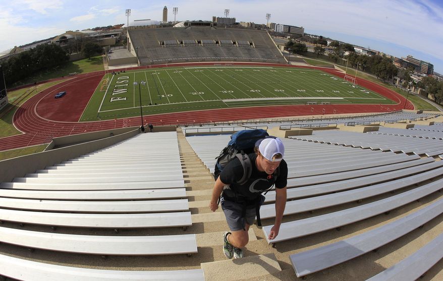 In this Feb. 17, 2014 photo, Matt Magoffin walks the stadium stairs at Farrington Field with his backpack loaded with sand in Fort Worth, Texas. They attract curious glances as they trudge through downtown, giant backpacks strapped to their backs and dragging weights on makeshift sleds behind them. They are Fort Worth firefighters, but they're not training for the next big blaze or building collapse. They're preparing for a self-imposed challenge, to climb to the highest point of North America. (AP Photo/The Fort Worth Star-Telegram, Paul Moseley) MAGS OUT; (FORT WORTH WEEKLY, 360 WEST); INTERNET OUT