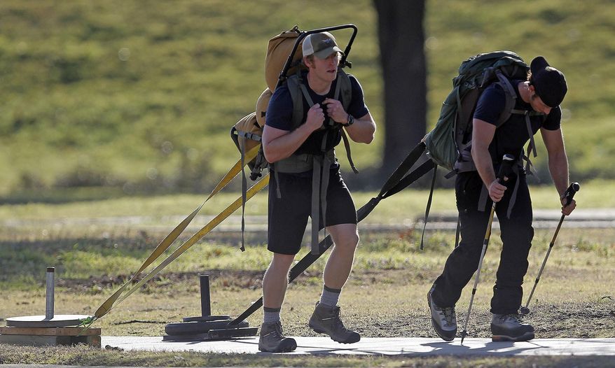 In this Feb. 18, 2014 photo, Fort Worth firefighters Daniel Ory, left, and Kasey Gandy pull weight sleds near Trinity Park to Farrington Field in Fort Worth, Texas. They attract curious glances as they trudge through downtown, giant backpacks strapped to their backs and dragging weights on makeshift sleds behind them. They are Fort Worth firefighters, but they're not training for the next big blaze or building collapse. They're preparing for a self-imposed challenge, to climb to the highest point of North America. (AP Photo/The Fort Worth Star-Telegram, Paul Moseley) MAGS OUT; (FORT WORTH WEEKLY, 360 WEST); INTERNET OUT