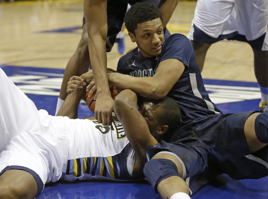 Marquette's Steve Taylor Jr., left, and Georgetown's Reggie Cameron reach for a loose ball during the first half of an NCAA college basketball game on Thursday, Feb. 27, 2014, in Milwaukee. (AP Photo/Jeffrey Phelps)