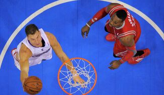 Los Angeles Clippers forward Blake Griffin, left, puts up a shot as Houston Rockets center Dwight Howard looks on during the first half of an NBA basketball game, Wednesday, Feb. 26, 2014, in Los Angeles. (AP Photo/Mark J. Terrill)