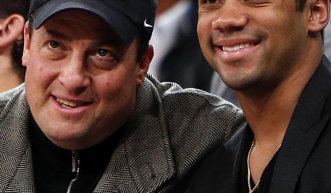 Kenny Dichter, CEO of Wheels Up, left, and Seattle Seahawks quarterback Russell Wilson pose for a photograph together as they attend an NBA basketball game between the Dallas Mavericks and the New York Knicks, Monday, Feb. 24, 2014, in New York. Dallas won 110-108. (AP Photo/Jason DeCrow)
