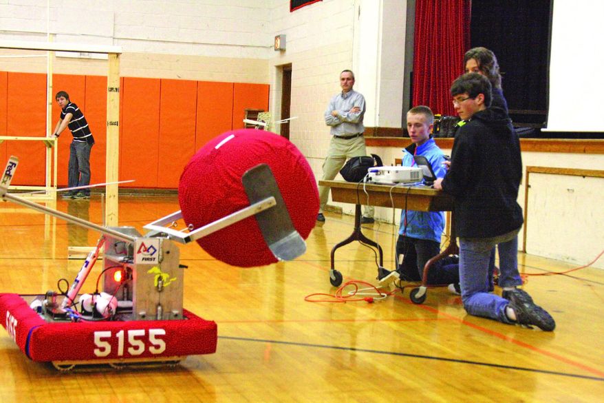 ADVANCE FOR MONDAY, MARCH 3 - In this photo taken on Feb. 18, 2014, students control the school's robot during an assembly at Ubley High School in Ubley, Mich. A six-week project to build, program and operate a robot to compete in state robotic games was unveiled at the school to a group of school board members, parents and business representatives. (AP Photo/Huron Daily Tribune, David Shane)