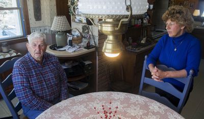 In this Feb. 10, 2014 photo, Judy Bates listens as her husband, Roger, talks about being rescued from his grain bin on Jan. 31 in Rockton, Ill. The 78-year-old sank neck-deep into 35,000 bushels of corn while trying to break up spoiled clumps of material that would have clogged the machines. (AP Photo/Rockford Register Star, Max Gersh)  MANDATORY CREDIT