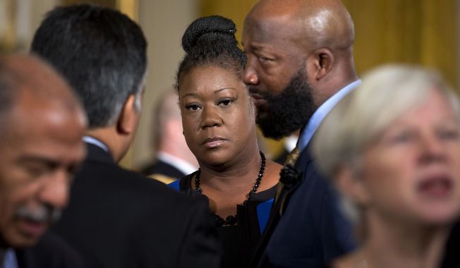 Sybrina Fulton, left, and Tracy Martin, parents of slain teenager Trayvon Martin, hear President Obama discuss his &quot;My Brother&#x27;s Keeper&quot; initiative at the White House in this Thursday, Feb. 27, 2014, file photo. (AP Photo/Jacquelyn Martin) ** FILE **