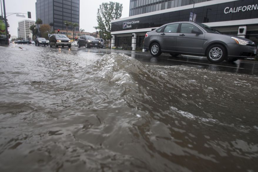 Motorists drive by a flooded portion of Ventura Blvd., in Sherman Oak, section of Los Angeles Friday, Feb. 28, 2014. The first wave of a powerful Pacific storm spread rain and snow early Friday through much of California, where communities endangered by a wildfire just weeks ago now faced the threat of mud and debris flows. (AP Photo/Ringo H.W. Chiu)