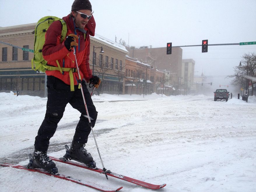 Cameron Best skies from his house across the street to Worden's Market for a beer Friday morning, Feb. 28, 2014, as much of downtown Missoula, Mont. was deserted due to a snowstorm. (AP Photo/The Missoulian, Martin Kidston)