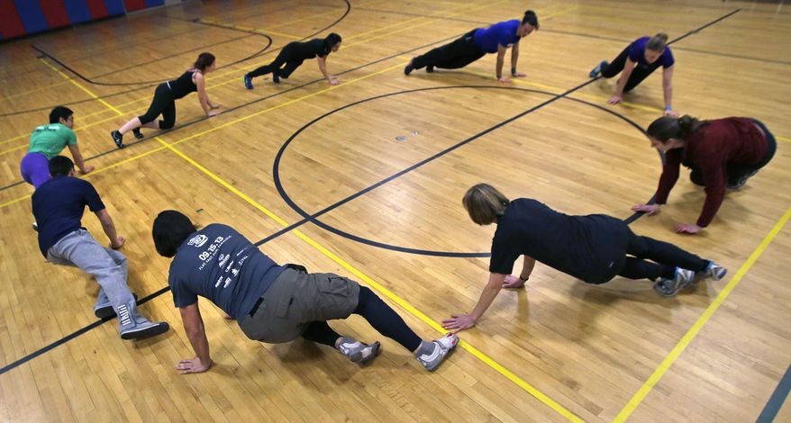 Participants warm up in a circle as a group before a Parkour training class in Brookline, Mass., Wednesday, Jan. 29, 2014. (AP Photo/Charles Krupa)