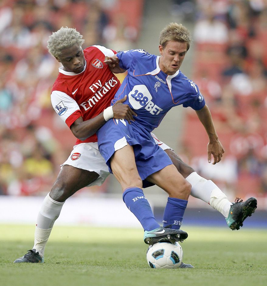 FILE- In this Sept. 11, 2010, file photo, Arsenal's Alexandre Song, left, vies for the ball with Bolton Wanderers' Stuart Holden during an English Premier League soccer match at Arsenal's Emirates Stadium in London. Holden is set to play his first match since being sidelined by another major knee injury last year.  Bolton manager Dougie Freedman says Holden will play Monday, March 3, 2014 for the English team's under-21s against Everton. (AP Photo/Kirsty Wigglesworth, File)