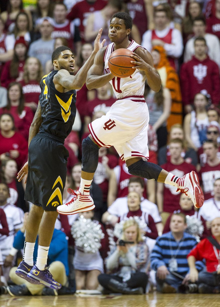 Indiana's Yogi Ferrell (11) changes course and looks for a teammate to pass to as Iowa's Roy Devyn Marble (4) goes up to defend against his efforts in the first half of an NCAA college basketball game on Thursday, Feb. 27, 2014, in Bloomington, Ind. (AP Photo/Doug McSchooler)