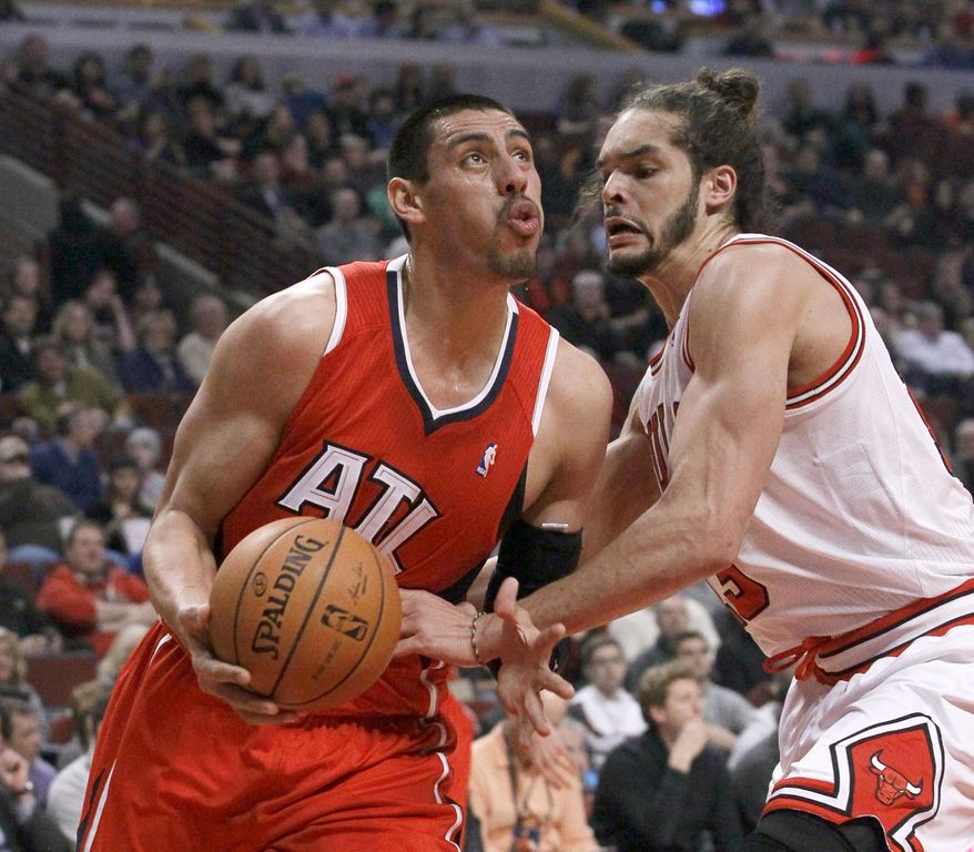 FILE - In this Feb. 11, 2014 file photo, Atlanta Hawks forward Gustavo Ayon (14), of Mexico, looks to the basket as Chicago Bulls center Joakim Noah (13) defends during the first half of an NBA basketball game in Chicago. Ayon will miss the remainder of the season following surgery on his right shoulder. Ayon's surgery on Friday, Feb. 28, 2014, was performed in Atlanta. (AP Photo/Charles Rex Arbogast, File )