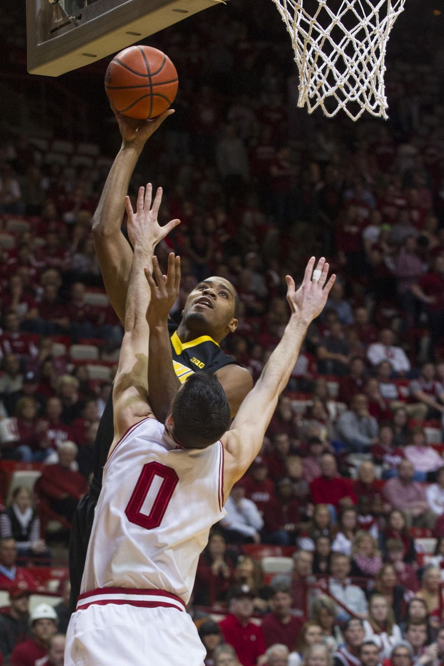 Iowa's Melsahn Basabe, top, shoots over Indiana's Will Sheehey (0) in the first half of an NCAA college basketball game on Thursday, Feb. 27, 2014, in Bloomington, Ind. (AP Photo/Doug McSchooler)