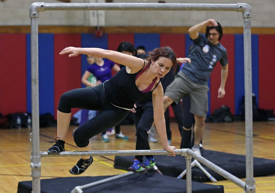 In this Wednesday, Jan. 29, 2014 photo, Jessamyn Hodge, of the South Boston neighborhood of Boston, leaps over a railing during a Parkour training class in Brookline, Mass.(AP Photo/Charles Krupa)