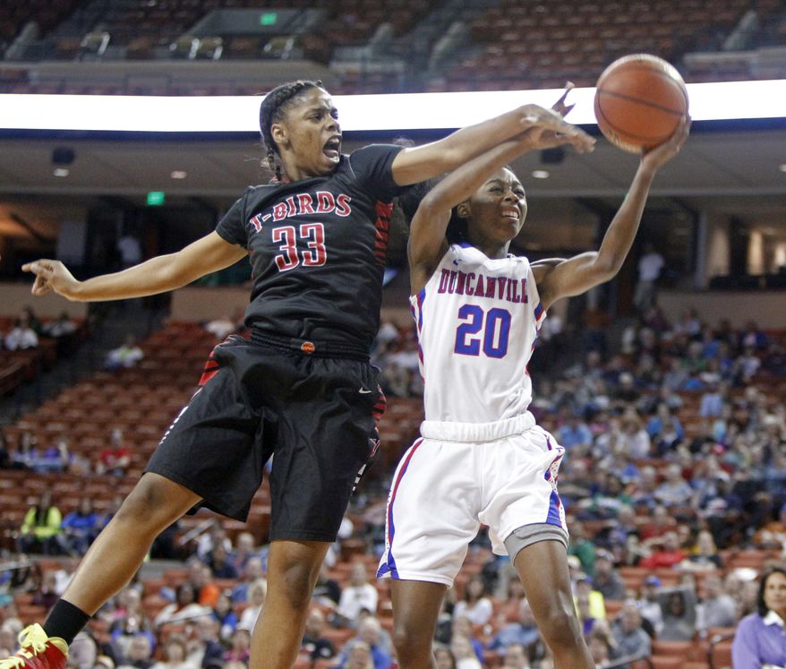 Duncanville guard Tasia Foman (20) lays the ball up against San Antonio Wagner guard Kaelynn Wilson (33) during a girls' UIL Class 5A state basketball semifinal, Friday, Feb. 28, 2014, in Austin, Texas. (AP Photo/Michael Thomas)