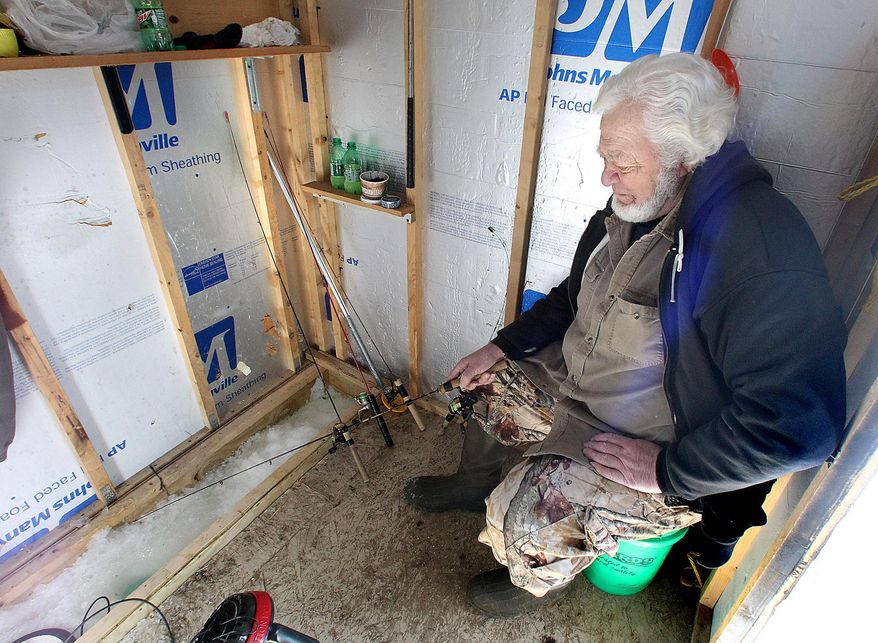 In this photo taken on Thursday, Feb. 28, 2014, Harold Lynch fishes in his ice shanty on Lake Onalaska in Onalaska, Wis. March 1 is Wisconsin’s deadline for removing ice fishing houses, but anglers are calling in to say their shanties are still stuck to the ice. The DNR sent out a press release saying they can’t change the law, but they’ll use discretion in enforcing the law with fishermen. (AP Photo/The La Crosse Tribune, Erik Daily)