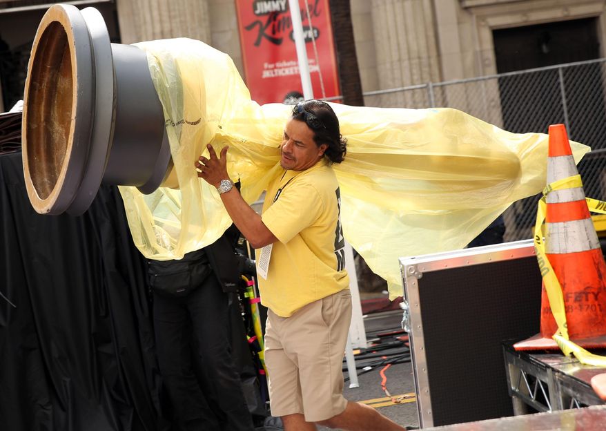 Johnny Tamayo carries an Oscar statue as preparations are made for the 86th Academy Awards in Los Angeles, Thursday, Feb. 27, 2014. The Academy Awards will be held at the Dolby Theatre on Sunday, March 2. (Photo by Matt Sayles/Invision/AP)