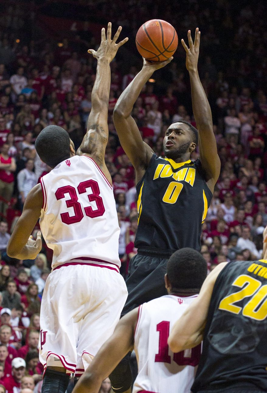 Iowa's Gabriel Olaseni (0) shoots over Indiana's Jeremy Hollowell (33) in the first half of an NCAA college basketball game on Thursday, Feb. 27, 2014, in Bloomington, Ind. (AP Photo/Doug McSchooler)