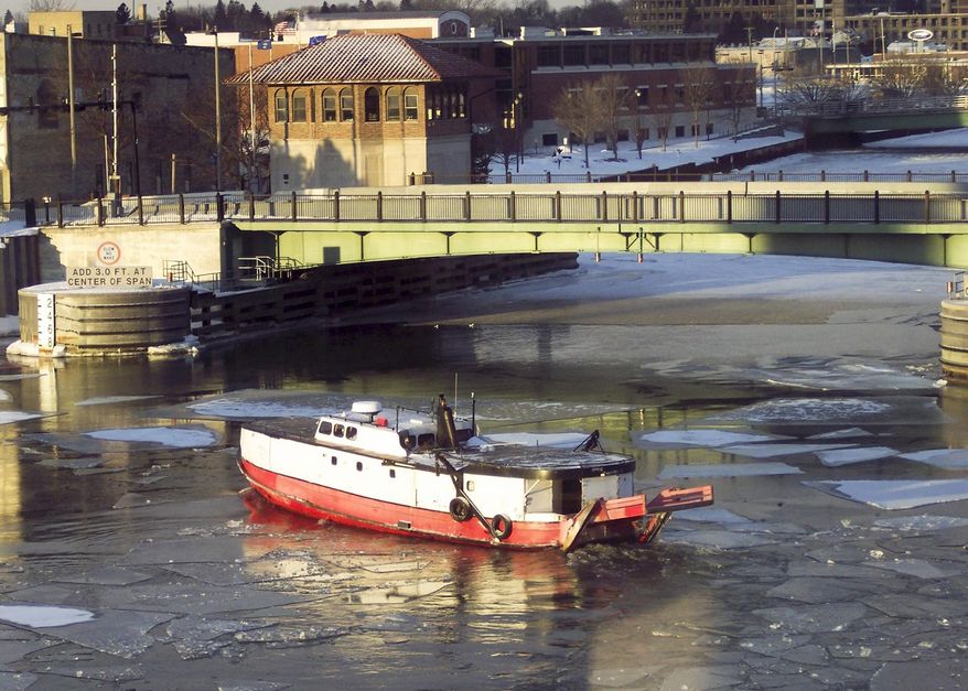 The Susie-Q fishing trawler, from the Susie-Q Fish Co. in Two Rivers, Wisc.,breaks up the ice on the Manitowoc River in Manitowoc, Wisc., Thursday, Feb. 27, 2014 so that hungry ducks can dive into the water for minnows and mussels. The brutal cold winter has frozen inland waters and a large portion of Lake Michigan is covered in ice this year. (AP Photo/Herald-Times Reporter, Katelyn Sheck) NO SALES