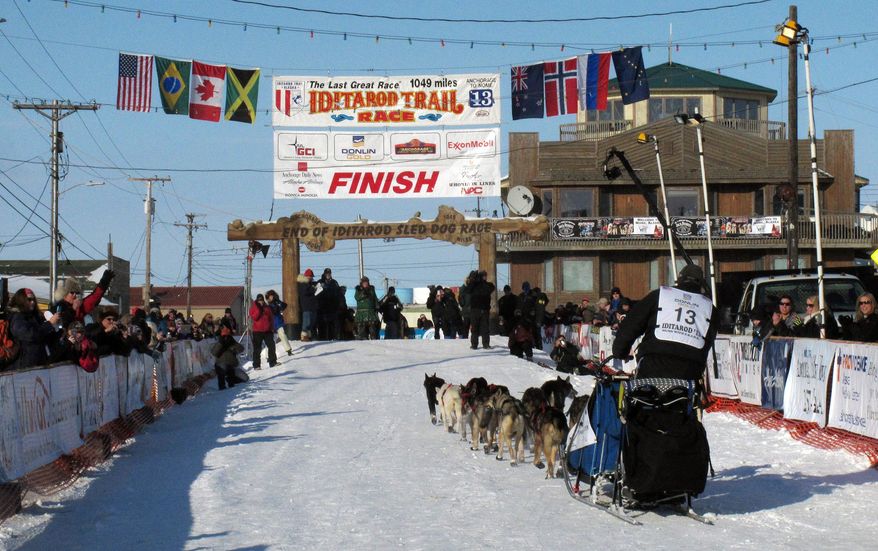 File - In this March 13, 2013 file photo, residents greet Kotzebue musher John Baker as he nears the finish line in the Iditarod Trail race in Nome, Alaska. Warm weather during much of the winter across Alaska nearly prompted officials at the Iditarod Trail Sled Dog Race to move the start to Fairbanks for the first time in a decade. But temperatures have dropped, and the 42nd running of the race across Alaska will start just as normal this weekend in Anchorage.(AP Photo/Mark Thiessen, File)