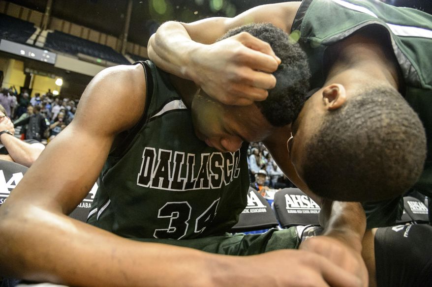 Dallas County's Roderic Leshore hugs teammate William Lee after defeating Johnson in a boys 4A state championship basketball game, Saturday, March 1, 2014, in Birmingham, Ala. Dallas County won in overtime 51-48. (AP Photo/AL.com, Vasha Hunt) MAGS OUT