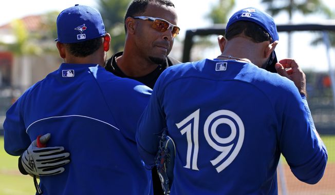Baltimore Orioles' Nelson Cruz, center, visits with Toronto Blue Jays' Melky Cabrera,  left, and Jose Bautista (19) before an exhibition spring training baseball game in Sarasota, Fla.,  Saturday, March 1, 2014. (AP Photo/Gene J. Puskar)