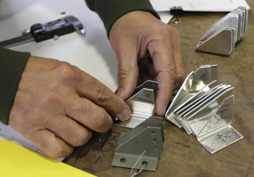Volunteer Shonil Datta compares several fabricated parts with to an original salvaged part, foreground, for a B-17 World War II-era bomber being built at the Champaign Aviation Museum in Urbana, Ohio on Thursday, Feb. 20, 2014. Volunteers are fabricating any parts of the plane that can't be found from other salvaged planes. (AP Photo/Al Behrman)