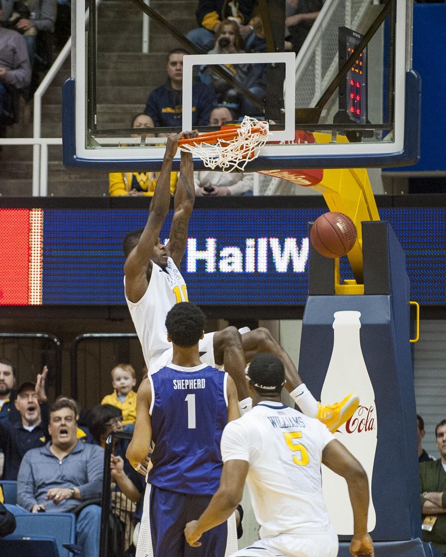 West Virginia's Eron Harris, top, dunks during the first half of an NCAA college basketball game against TCU, Saturday, March 1, 2014, in Morgantown, W.Va. (AP Photo/Andrew Ferguson)