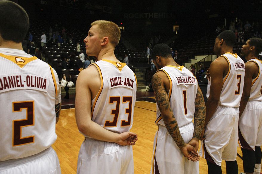 Winthrop basketball players Carlin Bremner (2), Hunter Sadlon (33), Brandon Vega (1) and Christian Farmer (3) wear the first names of children killed in the Newtown, Conn., school shooting on their jerseys during ceremonies before an NCAA college basketball game against Presbyterian in Rock Hill, S.C. on Saturday, March 1, 2014. (AP Photo/Nell Redmond)