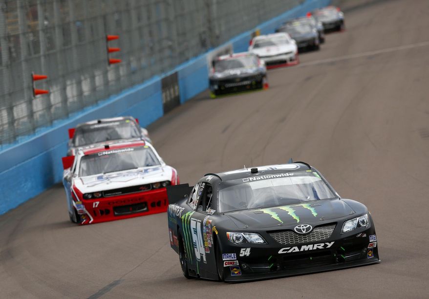Kyle Busch leads a group of drivers through the first turn during a NASCAR Nationwide auto race Saturday, March 1, 2014, in Avondale, Ariz. (AP Photo/Ross D. Franklin)