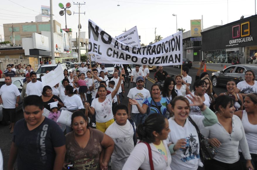 FILE - In this Feb. 26, 2014 file photo, people march in support of jailed drug boss Joaquin Guzman, "El Chapo," in the city of Culiacan, Mexico. Hundreds marched in the streets of the drug lord's bastion, demanding that Guzman be freed. Guzman, the one they called "shorty" because of his 5'6" frame grew up poor and had no formal education, would rise from a small-time Mexican marijuana producer to lead the world's most powerful drug cartel. (AP Photo/El Debate de Culiacan, Jonathan Telles, File)
