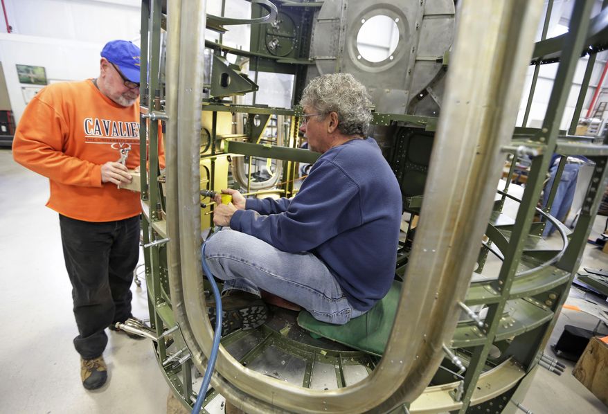 Volunteers Dave Weatherman, left, and Mike Pfarr work on an engine housing for a B-17 World War II-era bomber being built from salvaged and fabricated parts at the Champaign Aviation Museum in Urbana, Ohio on Thursday, Feb. 20, 2014. (AP Photo/Al Behrman)
