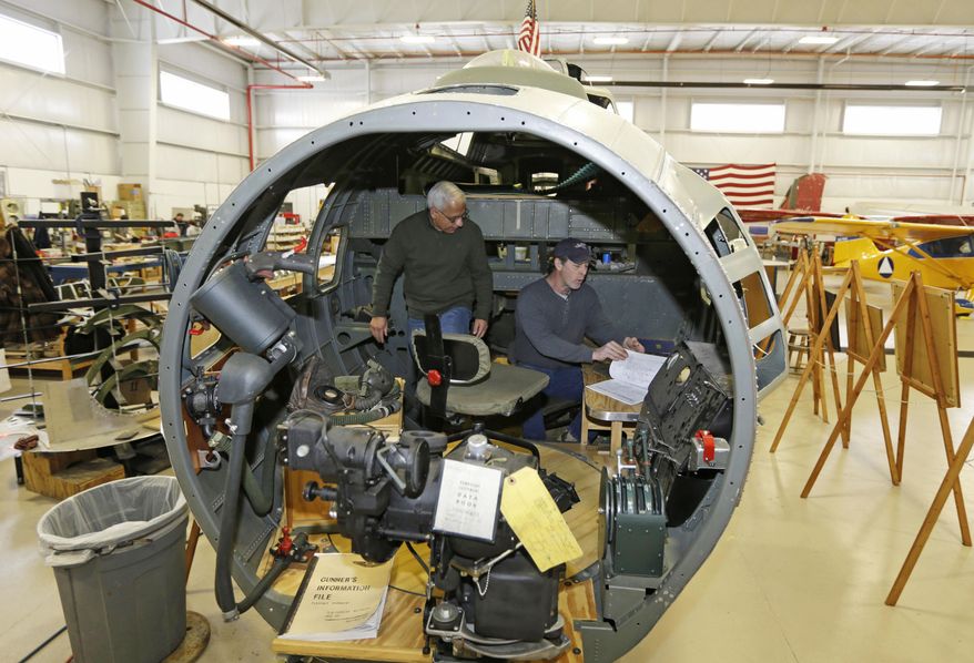Shonil Datta, left, and Rob Culbertson work inside the cockpit of a B-17 World War II-era bomber that is being built at the Champaign Aviation Museum in Urbana, Ohio on Thursday, Feb. 20, 2014. Any parts that can't be found from several salvaged planes are being fabricated by volunteers. (AP Photo/Al Behrman)