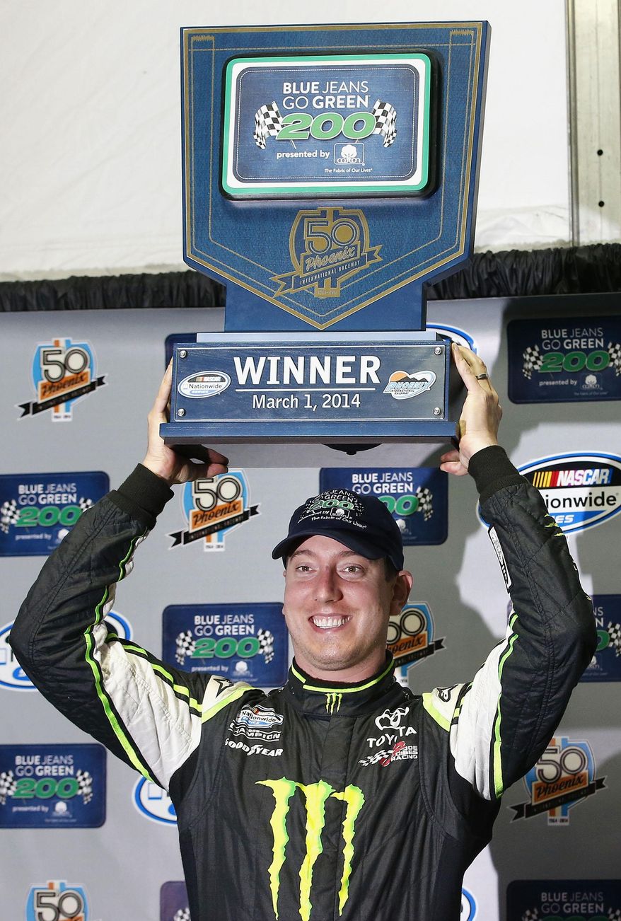 Kyle Busch poses for photographers with the winner&#39;s trophy after his victory in a rain-shortened NASCAR Nationwide auto race on Saturday, March 1, 2014, in Avondale, Ariz. (AP Photo/Ross D. Franklin)