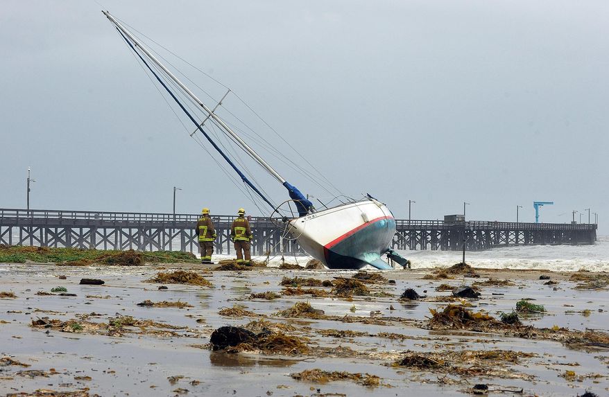 Santa Barbara County firefighters survey the scene after three sailboats washed ashore in Goleta, Calif., Saturday, March 1, 2014. The storm marked a sharp departure from many months of drought that has grown to crisis proportions for the state’s vast farming industry. However, such storms would have to become common to make serious inroads against the drought, weather forecasters have said. (AP Photo/Santa Barbara News-Press, Mike Eliason)