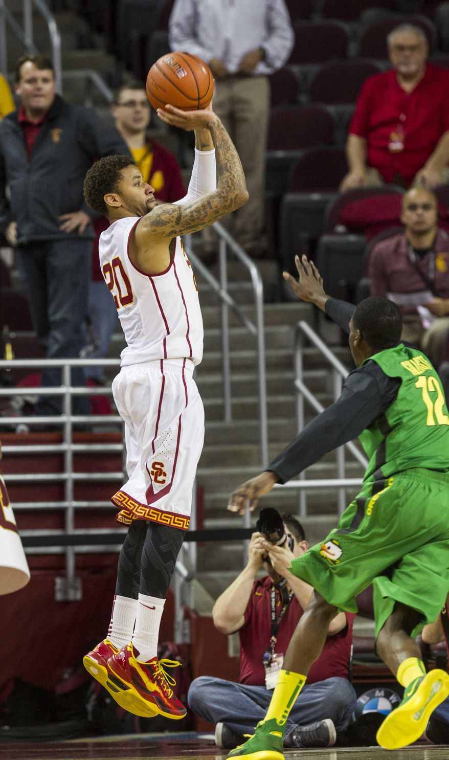 Southern California guard J.T. Terrell shoots a jump shot over Oregon guard Jason Calliste during the first half of an NCAA college basketball game Saturday, March 1, 2014, in Los Angeles. (AP Photo/Ringo H.W. Chiu)