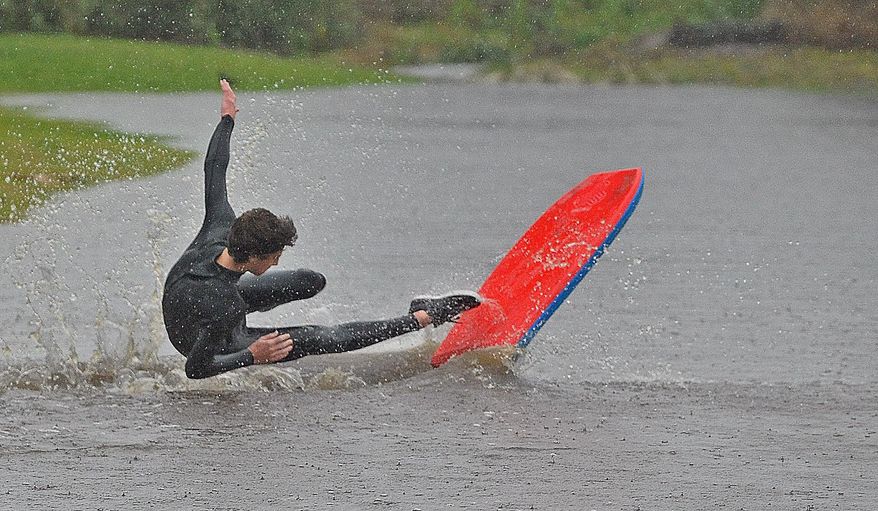Ryan Springer, 16, surfs a large puddle off in Carpinteria, Calif., Saturday, March 1, 2014. The storm marked a sharp departure from many months of drought that has grown to crisis proportions for the state’s vast farming industry. However, such storms would have to become common to make serious inroads against the drought, weather forecasters have said. (AP Photo/Santa Barbara News-Press, Mike Eliason)