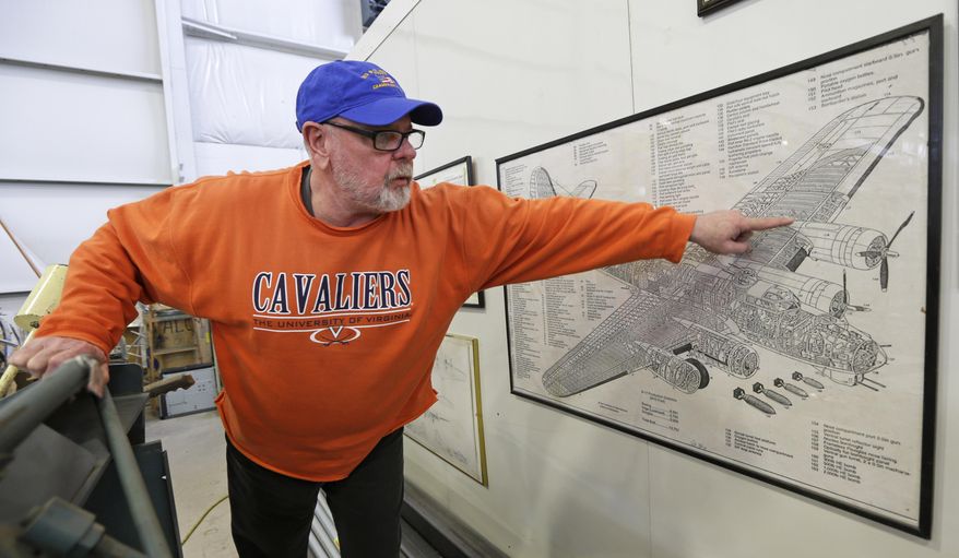 Volunteer Dave Weatherman points to the part of a B-17 World War II-era bomber he is helping build from salvaged and fabricated parts at the Champaign Aviation Museum in Urbana, Ohio on Thursday, Feb. 20, 2014. The project started in 2005 and is still years away from completion. (AP Photo/Al Behrman)