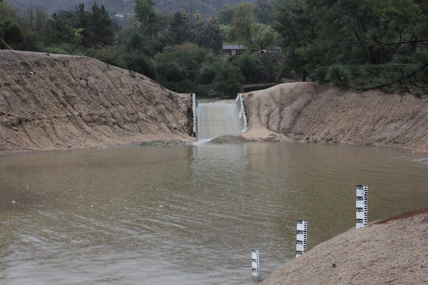 Storm water flows into a debris basin in Altadena, Calif., as thunderstorms dump rain on the San Gabriel Mountains on Saturday, March 1, 2014. Residents of some 1,200 homes in three foothill cities to the east were under evacuation orders due to danger of debris flows from steep slopes burned bare by recent wildfires. (AP Photo/ John Antczak)
