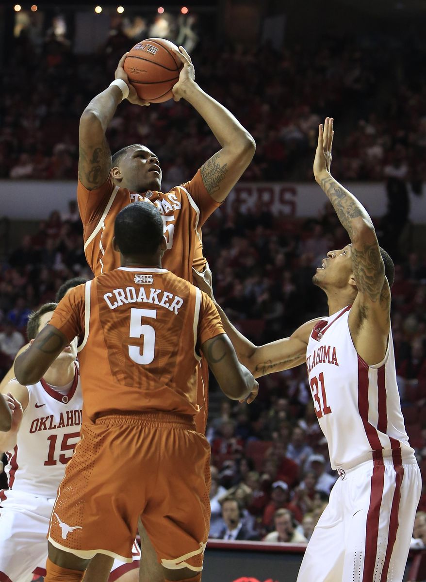 Texas center Cameron Ridley (55) shoots over Oklahoma forward Cameron Clark (21) as Texas guard Damaercus Croaker (5) watches during the first half of an NCAA college basketball game in Norman, Okla., Saturday, March 1, 2014. (AP Photo/Alonzo Adams)