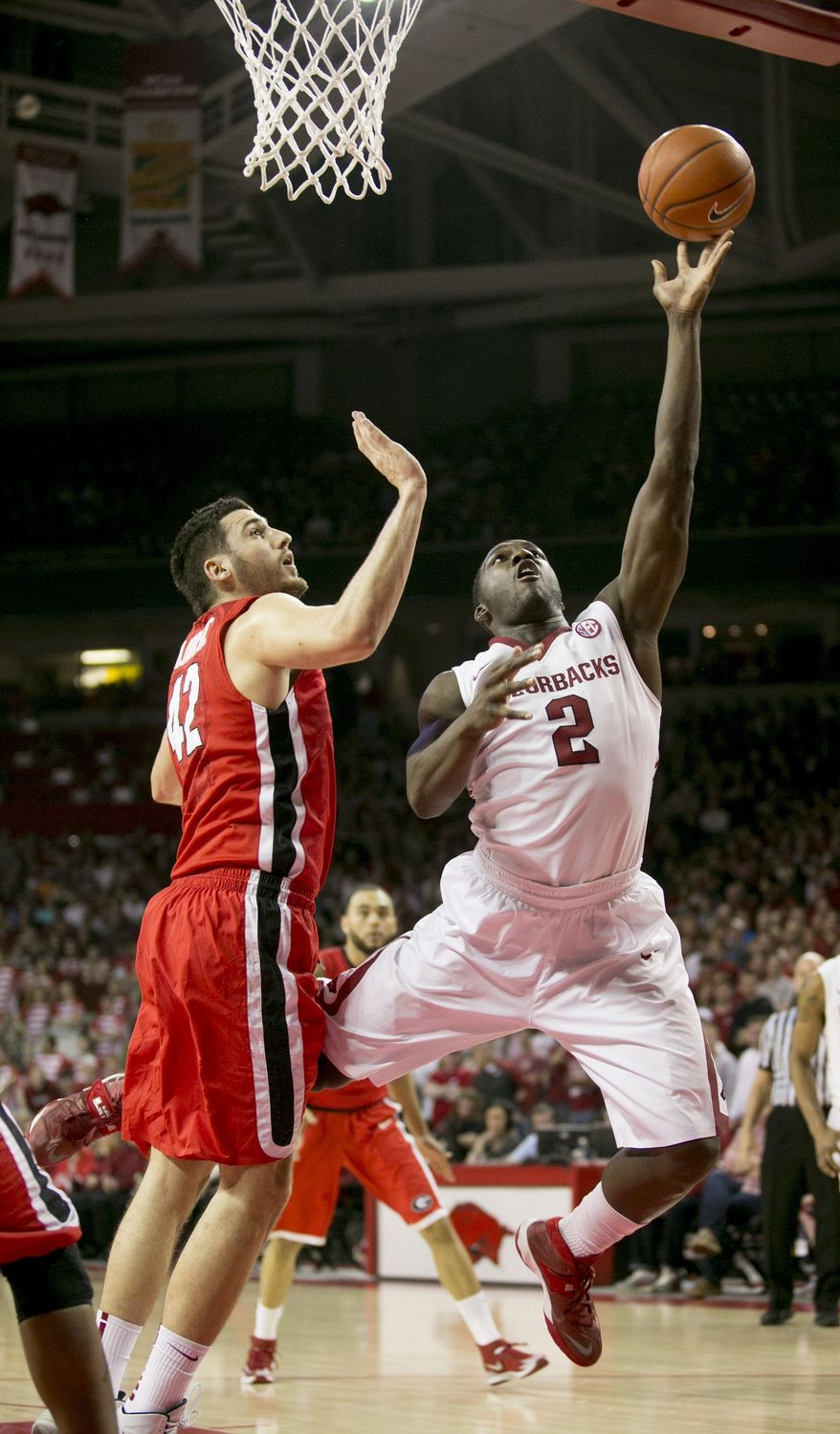 Arkansas forward Alandise Harris (2) goes up for a layup around Georgia forward Nemanja Djurisic (42) during the first half of an NCAA college basketball game on Saturday, March 1, 2014, in Fayetteville, Ark. (AP Photo/Gareth Patterson)