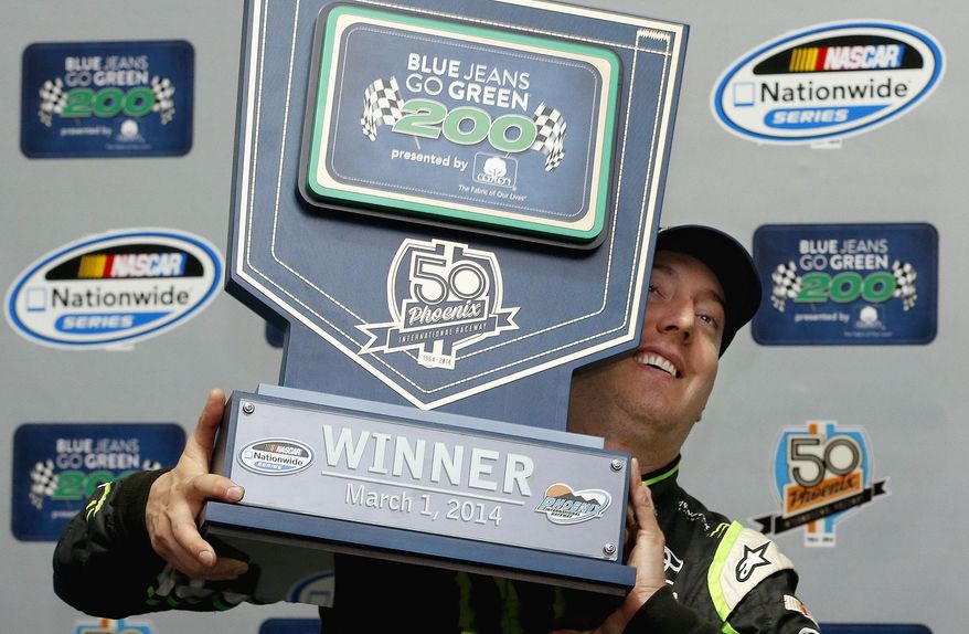 Kyle Busch poses for photographers with the winner&#39;s trophy after his victory in a rain-shortened NASCAR Nationwide auto race on Saturday, March 1, 2014, in Avondale, Ariz. (AP Photo/Ross D. Franklin)