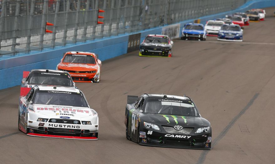 Kyle Busch, right, passes Brad Keselowkski, left, going into the first turn during a NASCAR Nationwide auto race Saturday, March 1, 2014, in Avondale, Ariz. (AP Photo/Ross D. Franklin)