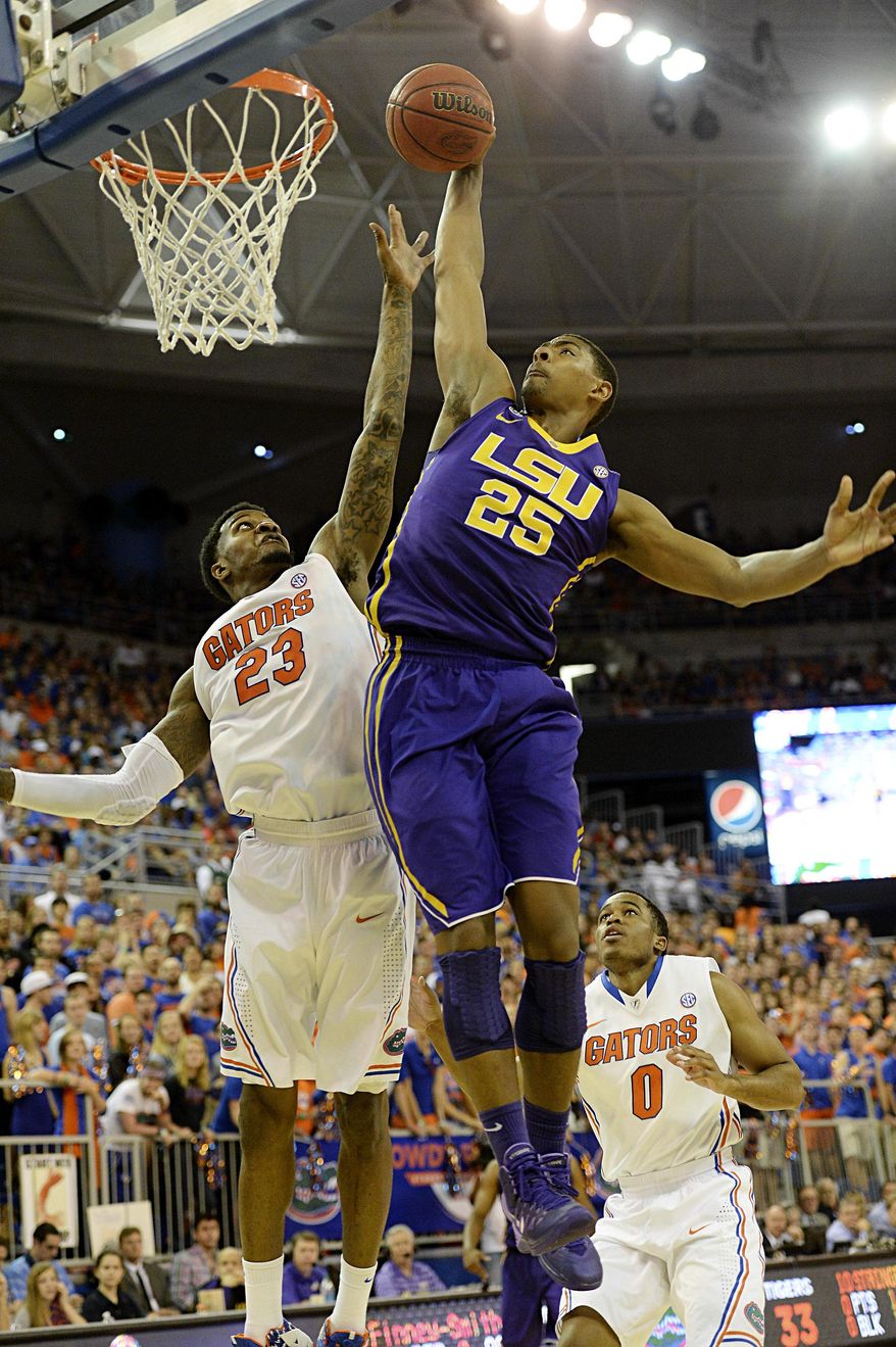 LSU forward Jordan Mickey (25) scores two points with Florida's Chris Walker (23) unable to block during the first half of an NCAA college basketball game on Saturday, March 1, 2014, in Gainesville, Fla. Floridfa defeated LSU 79-61.(AP Photo/Phil Sandlin)