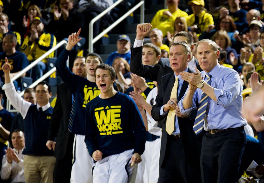 Michigan coach John Beilein, right, and the Michigan bench cheer after a basket during the first half of an NCAA college basketball game against Minnesota at Crisler Center in Ann Arbor, Mich., Saturday, March 1, 2014. Michigan won 66-56. (AP Photo/Tony Ding)