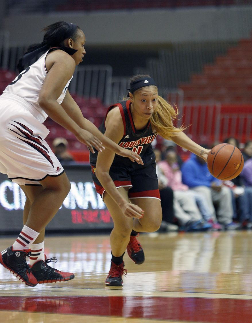 Louisville guard Antonita Slaughter (4) drives against Cincinnati forward Jeanise Randolph (33) during the first half of an NCAA college basketball game, Saturday, March 1, 2014, in Cincinnati. (AP Photo/David Kohl)