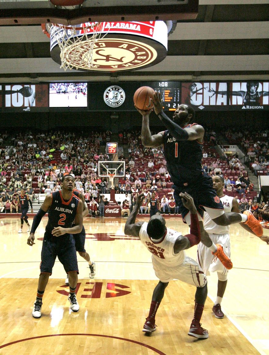 Alabama's Rodney Coper (21) draws a charge foul on Auburn's KT Harrell (1) as he goes up for a shot during the first half of an NCAA college basketball game on Saturday, Mar. 1, 2014, in Tuscaloosa, Ala. (AP Photo/Butch Dill)