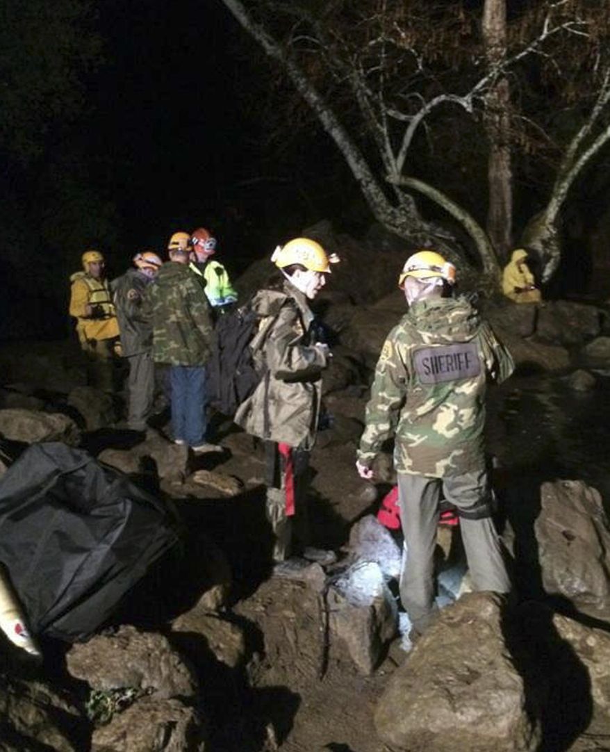 In this photo provided by the Los Angeles Sheriff's Department, Malibu Search and Rescue Team members assist four stranded hikers who were trapped overnight March 1, 2014 in a remote area of Malibu Creek State Park, Calif. Although the initial rescue area was inaccessible, the helicopter was finally able to connect with rescuers shortly after 3 a.m. and airlift the hikers to safety.(AP Photo/Los Angeles Sheriff's Department)