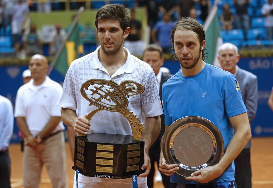 Argentina's Federico Delbonis, left, and Italy's Paolo Lorenzi, hold their trophies as they pose for pictures at the end of their Brazil Open ATP final tennis match in Sao Paulo, Brazil, Sunday, March 2, 2014. Delbonis won the open. (AP Photo/Andre Penner)