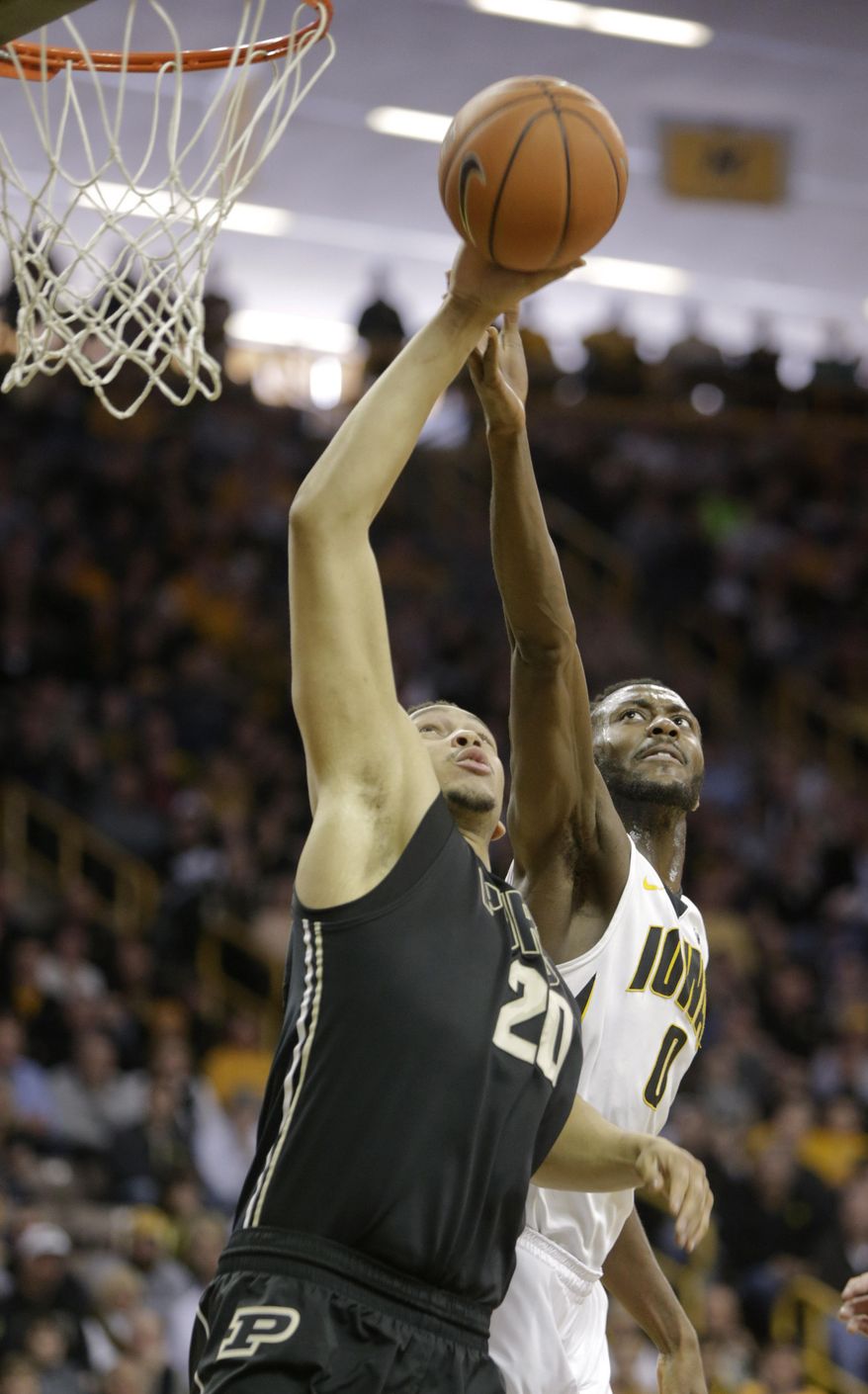 Iowa center Gabriel Olaseni, right, blocks a shot by Purdue center A.J. Hammons during the first half of an NCAA college basketball game on Sunday, March 2, 2014, in Iowa City, Iowa. (AP Photo/Jim Slosiarek)