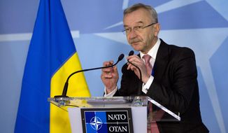 Ukraine&#39;s Ambassador to NATO Ihor Dolhov adjusts the microphones prior to speaking during a media conference at NATO headquarters in Brussels on Sunday, March 2, 2014. NATO is called emergency talks on Sunday regarding the escalating crisis in Ukraine. (AP Photo/Virginia Mayo)